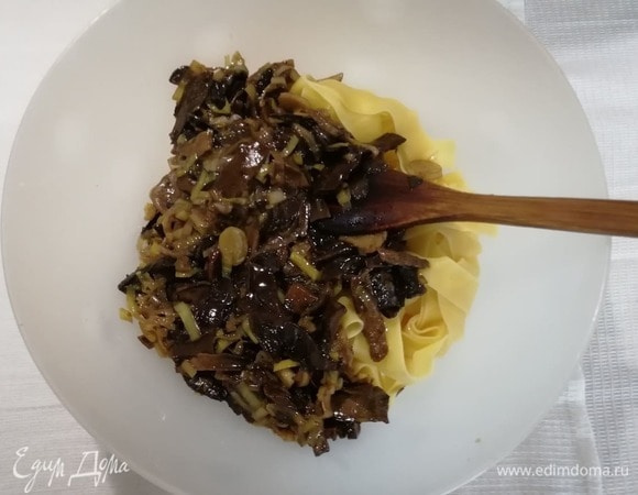 Добавить в макароны луково-грибной соус, 1 ст. л. оливкового масла и немного воды, в которой варились папарделле, поперчить и перемешать.