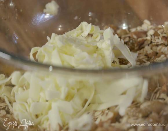 Геркулес, овсяные и льняные отруби, изюм, орехи, мусковадо высыпать в глубокую посуду, затем туда же натереть на терке предварительно охлажденное сливочное масло и перемешать все лопаткой.