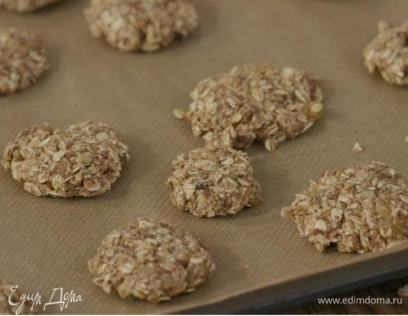 Сформировать из теста небольшие лепешки и выложить на противень, выстеленный бумагой для выпечки.