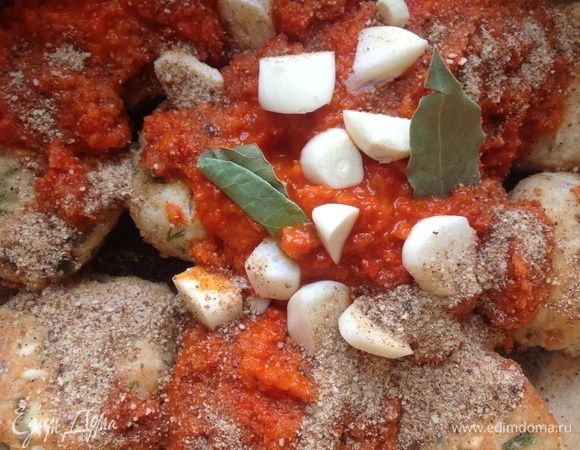 Кладу тефтели в жаровню. Добавляю сухари, нарезанный чеснок, лавровый лист, томатное пюре (у меня томатное пюре со сладким перцем).