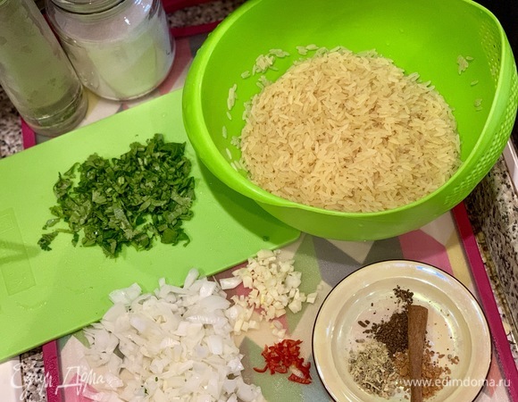 Когда поставили цыпленка и перепелов в духовку, готовим гарнир: промываем рис в холодной воде. Лук и чеснок почистить и мелко нарезать. Перец чили освободить от семян и тоже мелко нарезать. Кинзу мелку порубить. Подготовить специи.