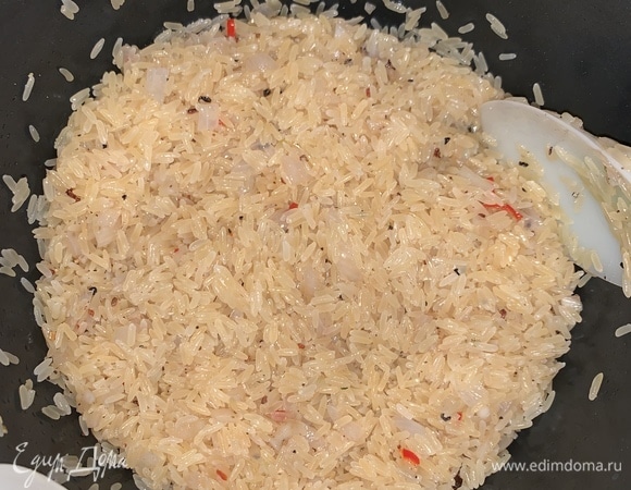 Всыпать рис, все перемешать. Залить рис 2 стаканами кипятка, накрыть крышкой, убавить огонь и варить 20 минут.