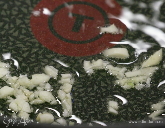 Пока лапша варится, сковороду-вок разогреть с оливковым маслом. Чеснок измельчить и выложить в вок.