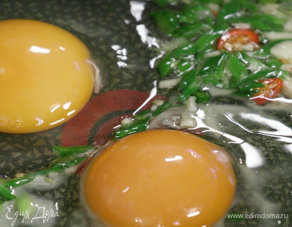 Когда лук станет мягким, вбить два яйца и смешать их с овощами.