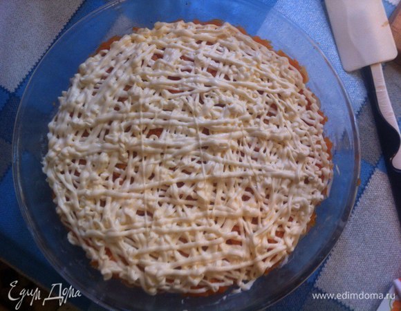 Трем заранее отваренную и очищенную морковь на крупной терке, можно сразу над формой с рыбой, немного солим и снова выкладываем сетку из майонеза.