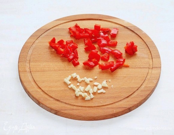 Чеснок почистить, раздавить плоской стороной ножа и мелко порубить. Сладкий перец нарезать маленькими кубиками, удалив семена.