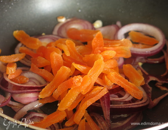 Добавляем курагу к луку, жарим 1–2 минуты.