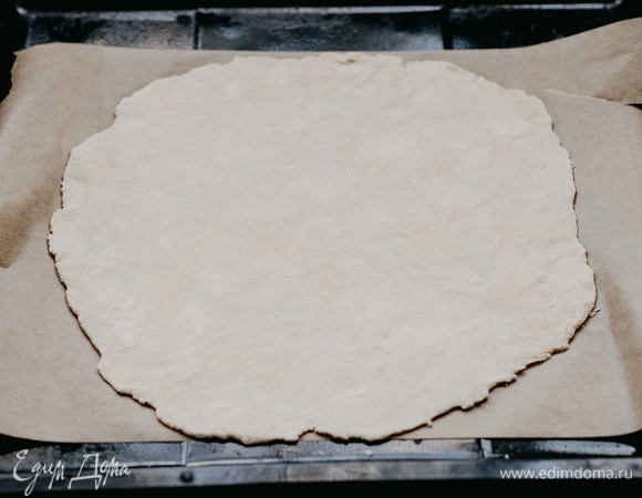 Тесто разделить на 2 части. Большую часть теста раскатать в тонкий пласт и выложить на бумагу для выпечки.