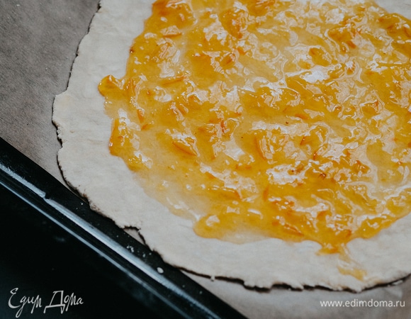 Отступая на 2 см от края пласта, смазать апельсиновым джемом.