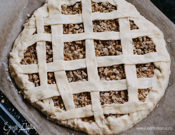 Оставшееся тесто тонко раскатать, нарезать полосками и украсить пирог. Желток соединить с 1 ст. л. молока, посолить, перемешать и смазать пирог. Выпекать в заранее разогретой до 200°C духовке 15–18 минут.