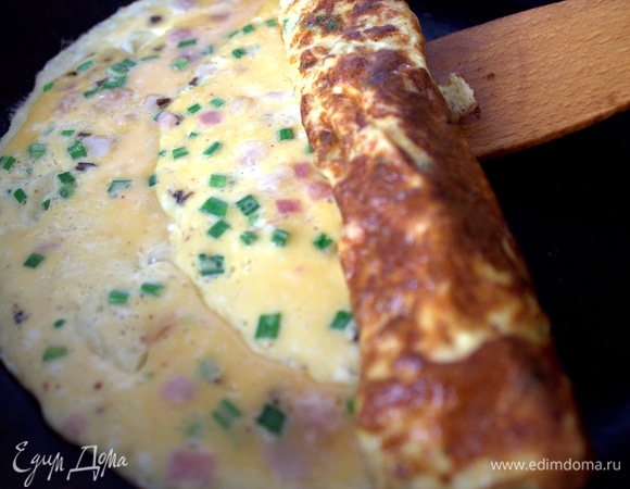 Ждем, когда омлет схватится, и сворачиваем в трубочку.