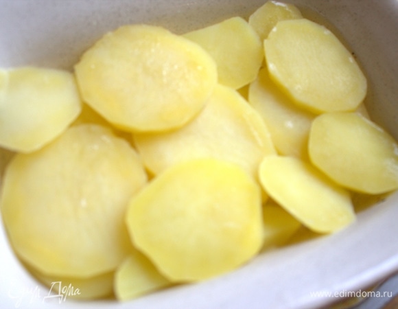 Слить воду и перенести часть долек в форму для запекания. Форму смазать оливковым маслом.