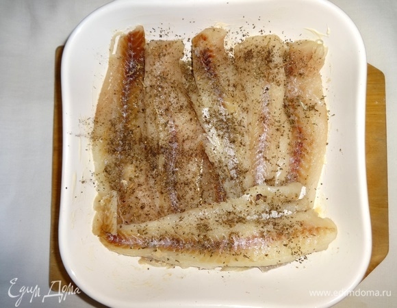 Выложить в форму филе рыбы, посолить, поперчить, посыпать сушеным базиликом, сбрызнуть лимонным соком.