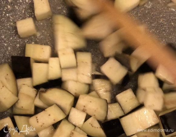 Нарезать кубиком баклажан. Разогреть сковороду с оливковым маслом, обжарить чеснок. Затем добавить баклажан и тушить почти до готовности баклажана.