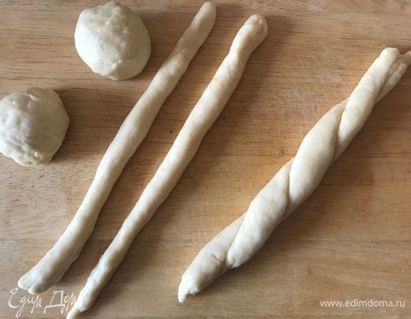 Поднявшееся тесто разделить на 16 шариков. Каждый шарик раскатываем в полоску, две полоски сворачиваем в жгутик.