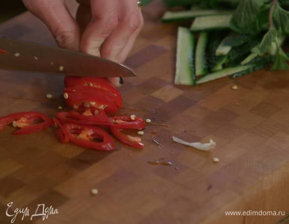 Перец чили вместе с семенами нарезать тонкими колечками.