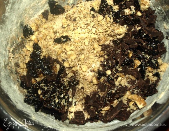 Чернослив промыть, обсушить и мелко нарезать. Шоколад мелко порубить. Грецкие орехи измельчить в ступке или порубить ножом. Добавляем в тесто и хорошо вымешиваем. Если необходимо, добавьте немного муки.