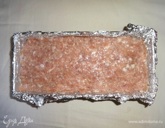 Выложить оставшийся фарш в форму, слегка прижимая. Смазать верх оставшимся растительным маслом. Поставить форму с мясным хлебом в духовку, разогретую до 180°C, на 45–50 минут.