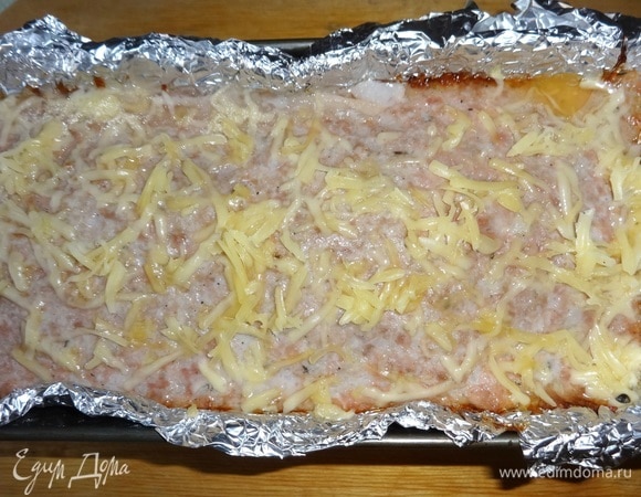 Перед окончанием приготовления достать форму и посыпать верх мясного хлеба оставшимся сыром. Поставить в духовку еще на несколько минут.