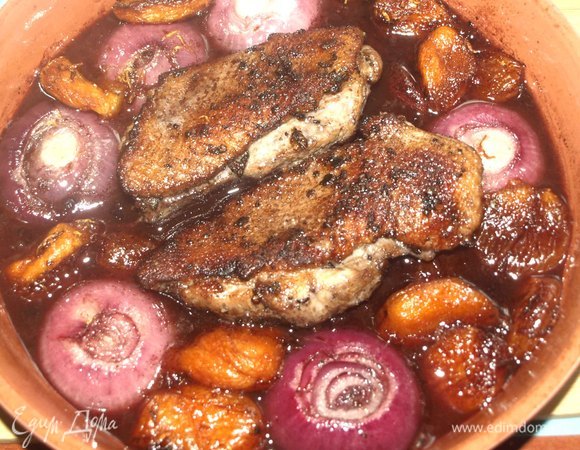 Достать противень из духовки, выкладываем грудки на лук и курагу. Отправляем на 8–10 минут обратно в духовку.