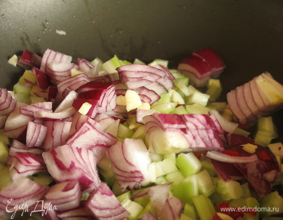 Разогреваем оставшееся масло, кладем сельдерей и лук. Добавляем чили и чеснок.