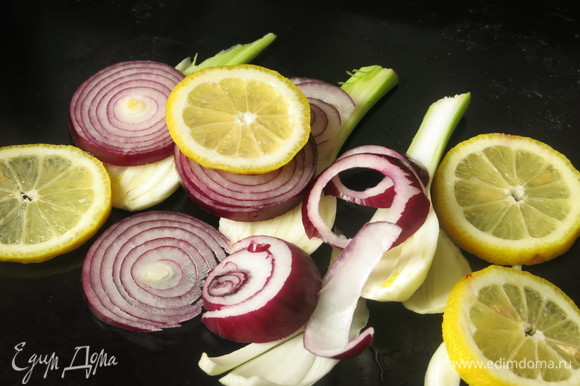 Разогреваем духовку до 200°C. На противень кладем половину овощей и лимонов.