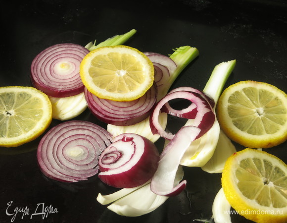 Разогреваем духовку до 200°C. На противень кладем половину овощей и лимонов.