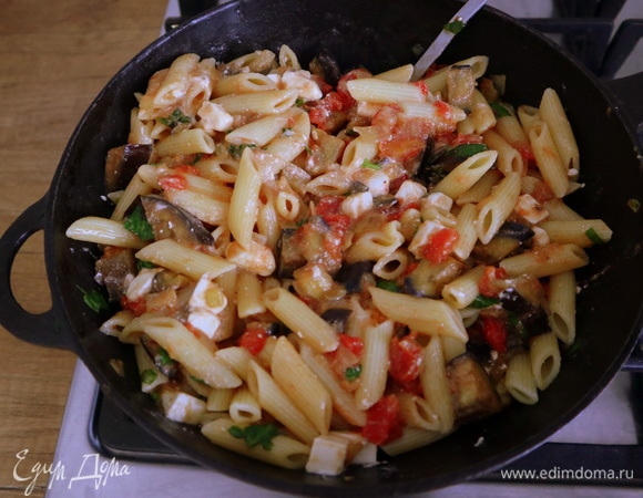 Отварить макароны в подсоленной воде, воду слить и сохранить. Выложить в сковороду к соусу макароны, нарезанную кубиками фету, половину листьев базилика и все вместе перемешать. Если получилось суховато, влить немного оставшейся после варки макарон воды и снова перемешать.