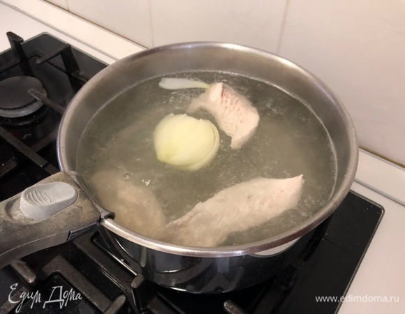 Доведите до кипения и снимите пену (посолить по вкусу). Добавьте в кипящий бульон половинку очищенного лука и варите около 15–20 минут.