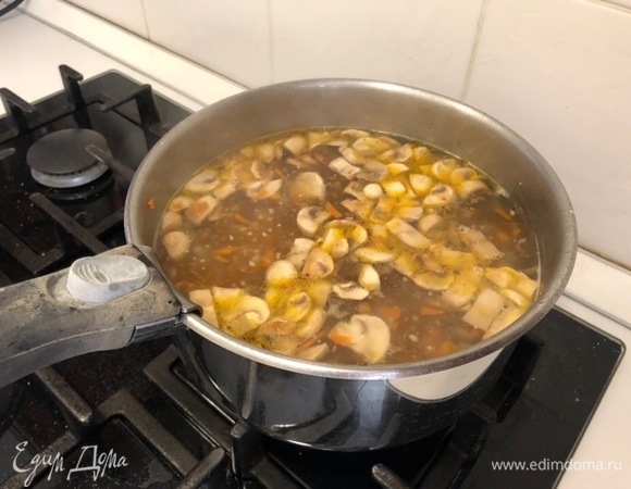 Когда бульон будет готов, достаньте курицу и добавьте в него готовые грибы, зажарку и лавровый лист. Варите минут 10–15 на среднем огне.