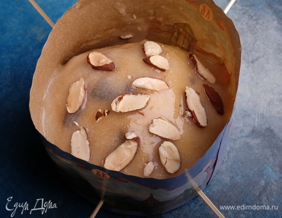 Духовку разогреть до 150°C. Смазать каждый кулич глазурью, сверху разложить нарубленный лепестками миндаль.