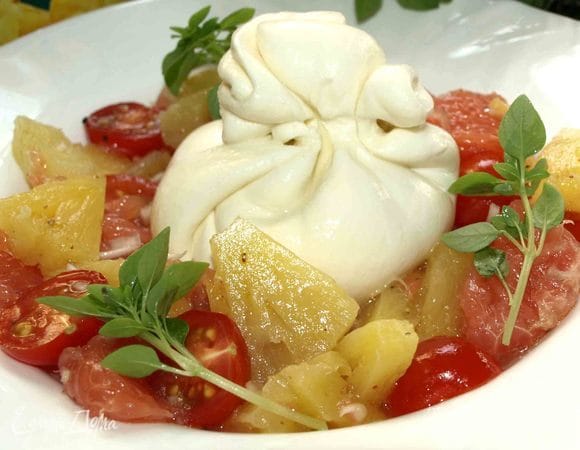Перекладываем в тарелку. В центр тарелки кладем мешочек сыра буррата. Добавляем базилик.