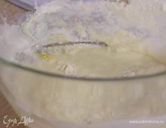 Взбивая массу венчиком, всыпать муку, смешанную с разрыхлителем, влить растопленное сливочное масло и тщательно вымешать тесто.