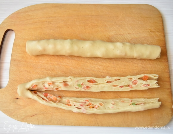 С помощью длинного острого ножа разрезать рулет вдоль пополам, не дорезая его до конца.