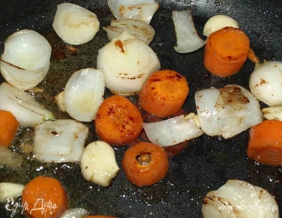 Лук, чеснок и морковь очистить. Морковь и лук крупно нарезать. Чеснок раздавить ножом. Обжарить овощи на сковороде, где жарили телятину.