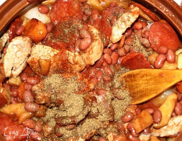 Через 40 минут достать из духовки мясо и добавить к остальным ингредиентам фасоль в томатном соусе. Посолить и поперчить по вкусу, добавить кориандр и лавровый лист. Закрыть крышкой и отправить еще на 20 минут в духовку.