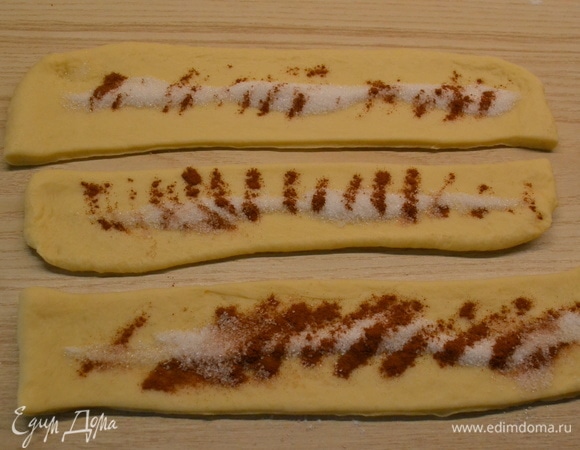 2/3 теста раскатать в прямоугольник толщиной примерно 5 мм. Нарезать на полоски 3 см шириной. В середину насыпать сахар с корицей.