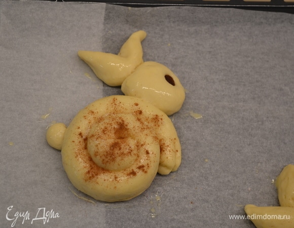 Смазываем яйцом, «тельце» посыпаем сахаром с корицей. Делаем из изюма глазки. Выпекаем около 30 минут при 170°C.