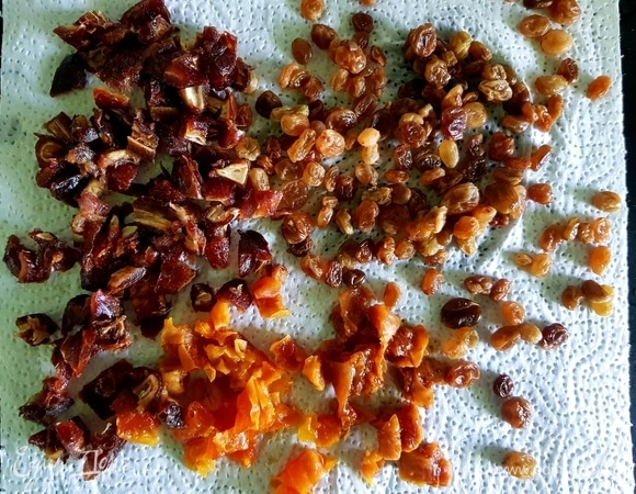 Сухофрукты залить кипятком и оставить на 1 час. После промыть, нарезать и обсушить на бумажном полотенце.