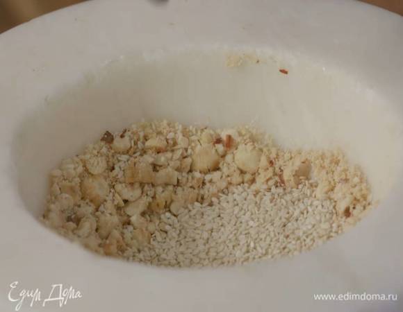 Фундук измельчить в ступке в крупную крошку, добавить кунжут, все перемешать и отложить 2 ст. ложки в другую посуду, а в ступку добавить апельсиновую цедру и перемешать с орехами.