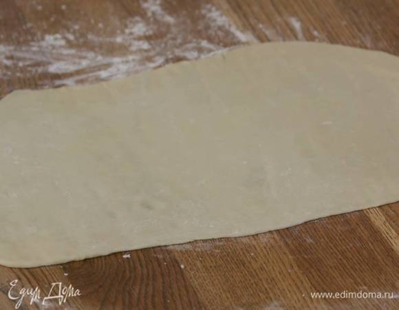 Тесто выложить на рабочую поверхность, присыпанную оставшейся мукой, и раскатать в тонкий пласт.