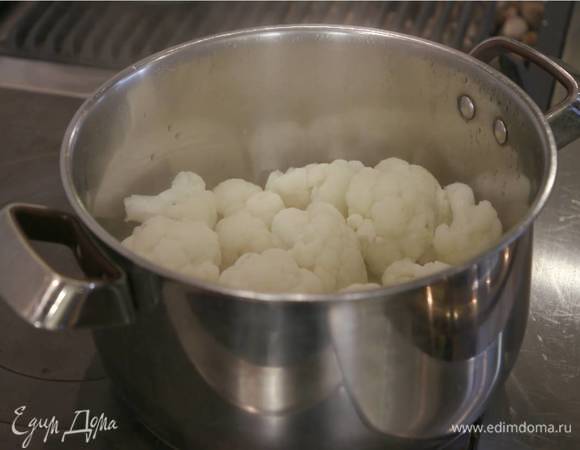 Цветную капусту разобрать на небольшие соцветия, плотным слоем выложить на чеснок с маслом, накрыть крышкой и готовить на небольшом огне 10‒15 минут, пока капуста не станет мягкой.<br />
 