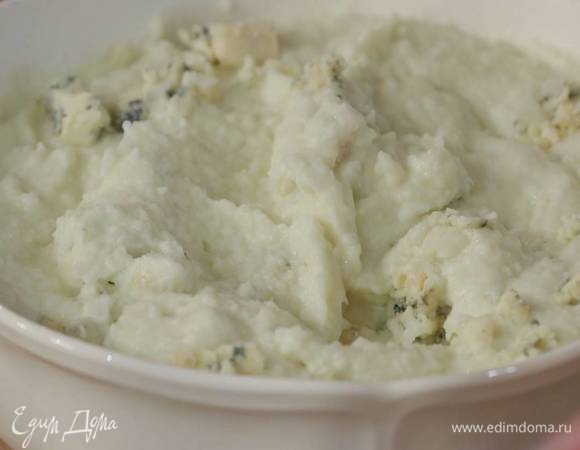 Выложить пюре в глубокую посуду, добавить пармезан и все перемешать, сверху разложить кусочки голубого сыра и слегка вмешать их в пюре.