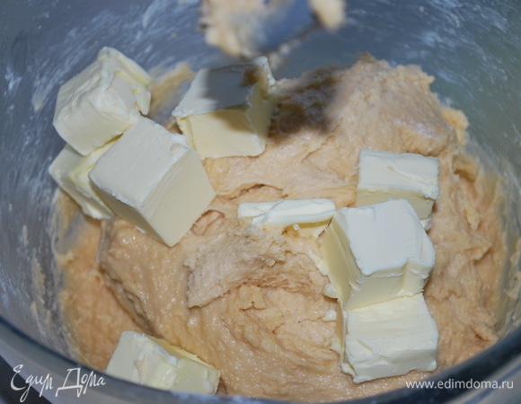 Введите в тесто порциями сливочное масло 82,5% до полного вмешивания в тесто.