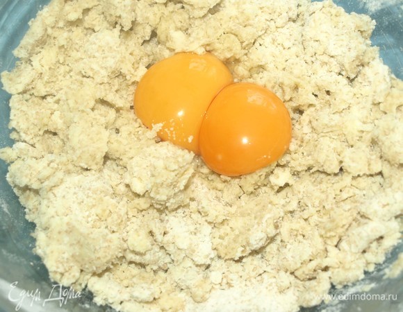 Тесто получится, как крупная крошка. Добавляем желтки.