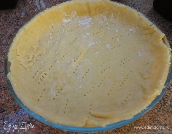 Форму для выпечки смажьте сливочным маслом и посыпьте мукой или застелите дно пекарской бумагой. Тесто раскатайте и выложите в форму с бортиками. Наколите вилкой. Накройте пекарской бумагой, засыпьте крупой и выпекайте 10 минут при температуре 200°C. Удалите наполнитель и подержите корж еще 5 минут в духовке. Вылейте крем, разровняйте и поместите в духовку еще на 10 минут при температуре 180°C.