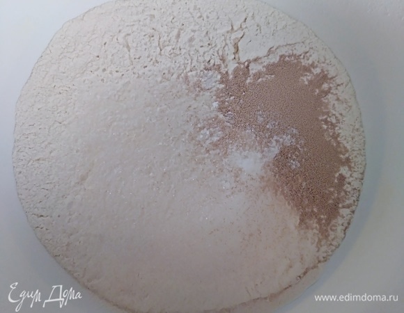 В большой миске соединить половину просеяной муки, сахар, соль, дрожжи и корицу. На упаковке дрожжей должна быть рекомендация «добавить в муку». Если написано «активировать», то действуйте по инструкции.