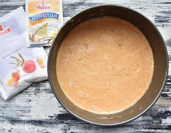 Печенье растолочь в крошку с помощью блендера. Можно сложить его в пакет и воспользоваться скалкой. Сливочное масло слегка растопить в микроволновой печи и, соединив с крошкой, перемешать. Дно формы выстелить пергаментом, распределить основу по всей поверхности, утрамбовать. Форму желательно использовать разъемную. Поставить форму в духовку, разогретую до 180°C. Выпекать основу минут 15.