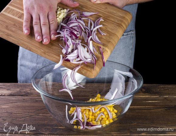 Смешайте в салатнике лук, чеснок, консервированную кукурузу. Добавьте рубленую зелень по вкусу.