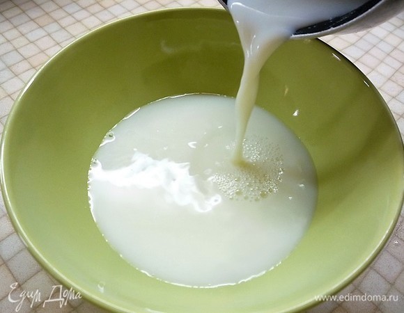 Для теста приготовим опару. В чашку наливаем теплые (примерно 37°C) 33% сливки. Добавляем 1 ст. л. сахара, перемешиваем до растворения сахара. Добавляем в сливки свежие дрожжи, перемешиваем и оставляем для активации на 15–20 минут. Сухих дрожжей понадобится 8 г.